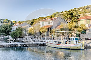 Yellow wooden boat on the pier in the bay of the Adriatic sea near the fishing village in the evening in Lavsa, Croatia photo