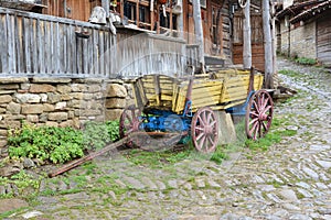 Yellow wooden cart in front of old house, Jeravna village, Bulgaria