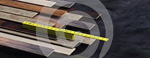 Yellow wooden folding ruler on laminate floor panels stack, black background, banner, copy space. 3d illustration