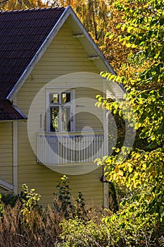 Yellow wooden house with a balcony on the gable