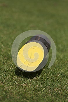 The yellow wooden marker on a golf course