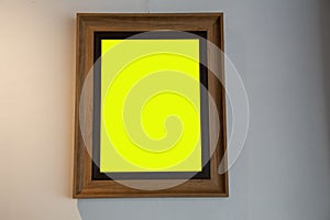 Yellow wooden picture frame attached to the wall