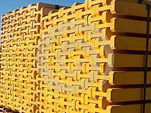 Yellow wooden piled formwork beams. Construction equipment