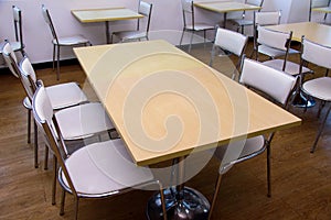 Yellow wooden table with white chairs in the dining room