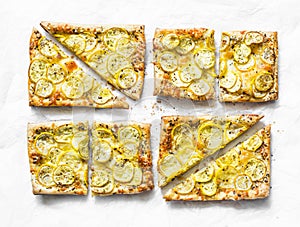 Yellow zucchini puff pastry mini tarts on a light background, top view. Tasty snack, tapas