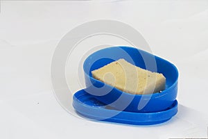 Yellowish dish washing sponge in the blue box