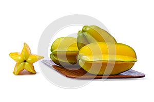 Yellowish green star fruit on the rounded rectangle wooden tray isolated on white background