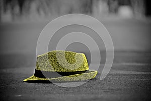 Yellowish hat kept on top of a surface of an empty street