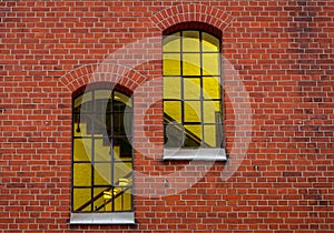 Yellowish-lit windows in a brick wall