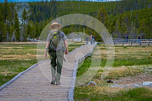 YELLOWSTONE, MONTANA, USA MAY 24, 2018: Outdoor view of female park ranger wearing a green uniform with a backpack