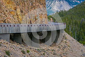 Yellowstone`s Grand Loop Road passes through the Golden Gate surrounded by steep and colorful volcanic rocky walls.
