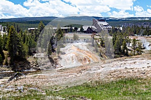 Yellowstone, Wyoming, USA, May 25, 2021, Tourists at the Firehole river and the Old Faithful Inn at the Upper Gyser Basin