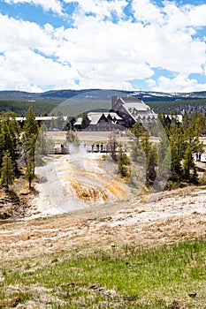 Yellowstone, Wyoming, USA, May 25, 2021, Tourists at the Firehole river and the Old Faithful Inn at the Upper Gyser Basin