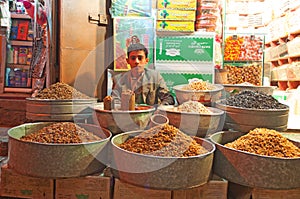 A yemeni boy, seated in his shop in the salt market of the Old City of Sana'a, suq, Yemen, seller, spices and nuts, daily life
