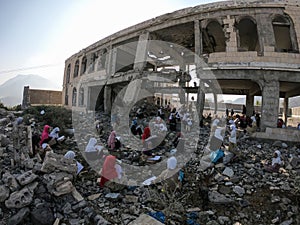 Yemeni children studying inside the destroyed area because of the war