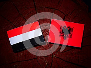 Yemeni flag with Albanian flag on a tree stump isolated