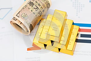 Yen banknotes and gold on documents