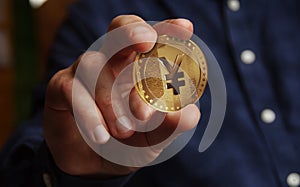 Yen Yuan cryptocurrency golden coin in hand 3d illustration