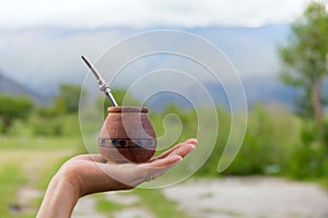 Yerba mate in a traditional calabash gourd, hand, space for your text