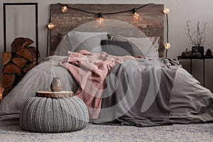 Yerba matte on wooden plate on grey woolen pouf in stylish bedroom