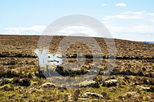 Yes in big white wooden letters with Scottish moorland in the background