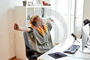 Yes. Female esport gamer, woman in headphones looking excited, winning, playing online video game on PC while recording