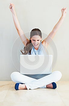 Yes. A pretty young woman cheering while looking at her laptop screen.