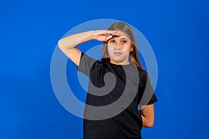 Yes sir. Portrait of responsible obedient little girl with braid in denim overalls saluting and looking at camera with