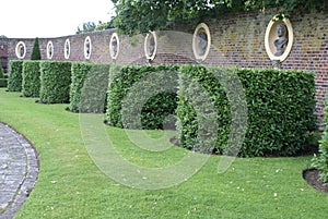 Yew topiary garden with statues in alcoves