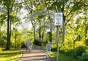 YIELD TO PEDS Sign on the bike and walking path in a wooded area