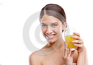 Yipee for vitamin C. Studio portrait of an attractive young woman holding a glass of orange juice.