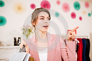 YNice lady standing in boutique and showing something with index finger