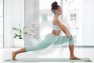 Yoga is all about balance. Full length shot of an attractive young woman practising yoga in the studio and holding a