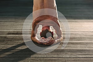 Yoga apprentice practicing sirsasana, inverted posture with the head resting on the floor