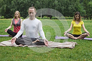 Yoga athletes in park - sportsmen in lotus pose