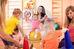 Yoga for baby. Child-friendly fitness for women with kids toddlers. Mothers with happy babies doing exercises with photo