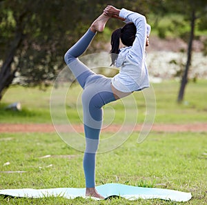 Yoga, balance and Indian woman stretching in park for wellness, healthy body and warm up in nature. Pilates, fitness and
