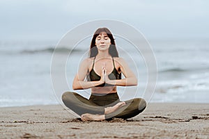 Yoga beach woman doing pose at the ocean