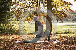 Yoga being practiced in the fall surround by autumn leaves