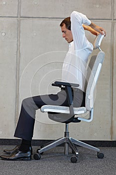 Yoga on chair in office - business man exercising