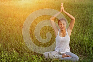 Yoga in the city: beautiful young fit woman wearing sportswear meditating, breathing, sitting with crossed legs in Half Lotus