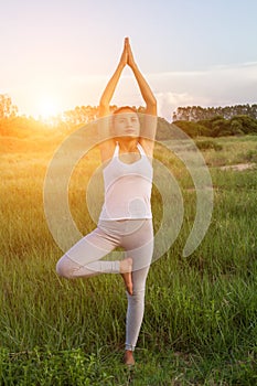 Yoga in the city: beautiful young fit woman wearing sportswear meditating, breathing, sitting with crossed legs in Half Lotus