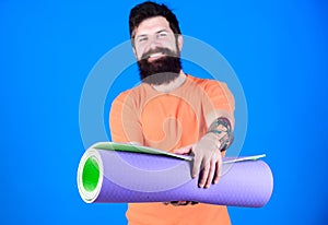 Yoga class concept. Yoga as hobby and sport. Practicing yoga every day. Man bearded athlete hold fitness mat. Fitness