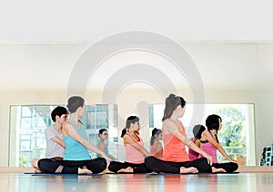 Yoga class in studio room,Group of people doing seated twist pose with relax emotion,Meditation pose,Wellness and Healthy Li