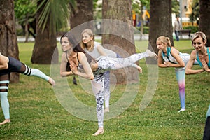 Yoga classes outdoor at park. Group of women exercising outdoors.