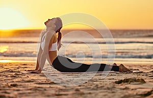 Yoga, cobra stretch and woman at beach for fitness, health and wellness. Sunset, zen chakra and female yogi practicing