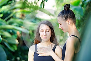 Yoga concept, meditation and sound therapy. Beautiful young girl at yoga session with her yoga and meditation teacher at