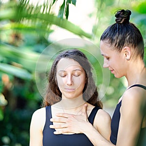 Yoga concept, meditation and sound therapy. Beautiful young girl at yoga session with her yoga and meditation teacher at