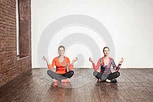 Yoga concept. Two cute woman sit in lotus pose and meditating