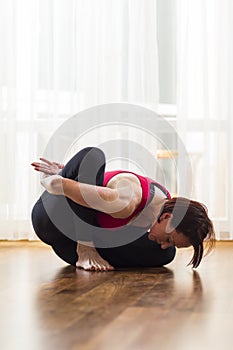 Yoga Concepts. Caucasian Woman Practicing Yoga Exercise Indoors At Bright Afternoon. Sitting in Marichiasana Pose During Solitude